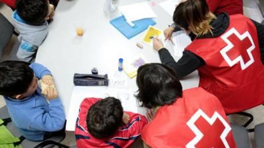 Miembros de la Cruz Roja vilera con niños en riesgo de exclusión.