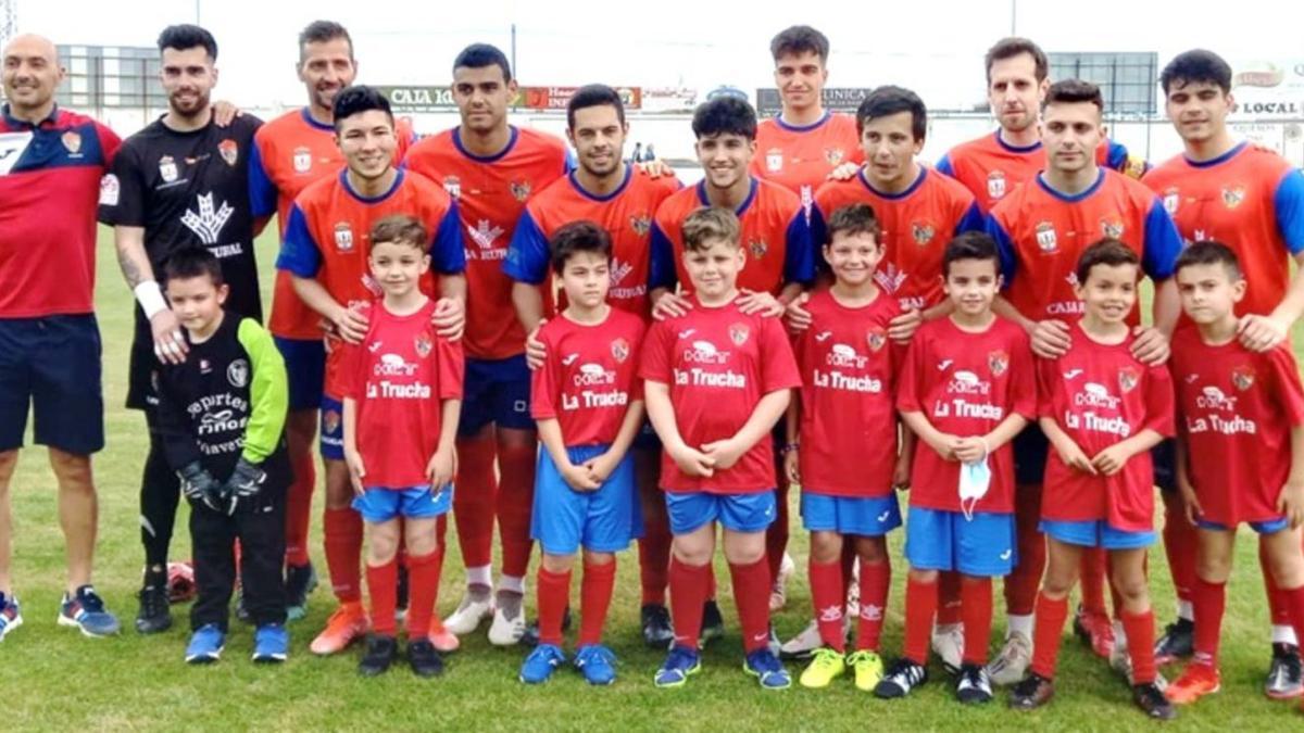 La plantilla del CD Benavente posa para las cámaras con varios canteranos del club. | Cedida