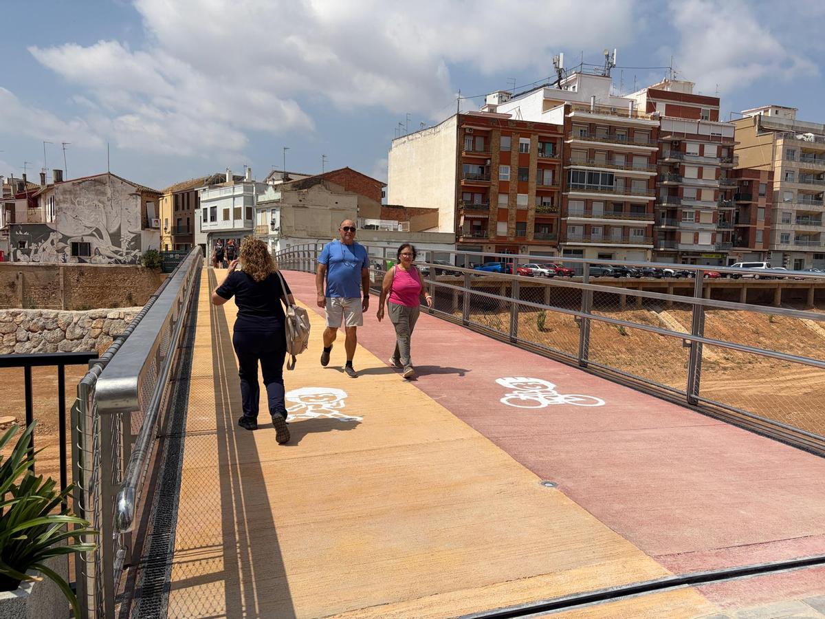 Los primeros viandantes cruzan la pasarela.