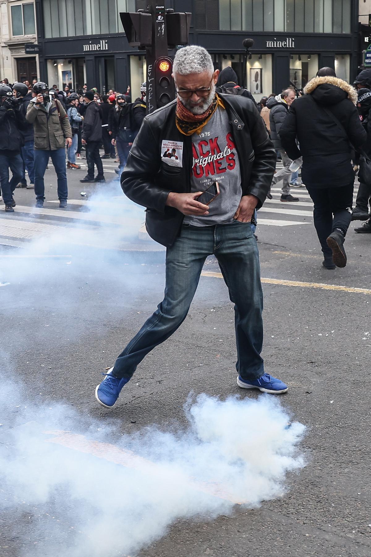 Paris (France), 23/03/2023.- A protester stands in tear gas fumes during clashes with anti-riot police during a demonstration against the government pension reform in Paris, France, 23 March 2023. Protests continue in France after the French prime minister announced on 16 March 2023 the use of Article 49 paragraph 3 (49.3) of the French Constitution to have the text on the controversial pension reform law be definitively adopted without a vote in the National Assembly (lower house of parliament). The bill would raise the retirement age in France from 62 to 64 by 2030. (Protestas, Francia) EFE/EPA/MOHAMMED BADRA