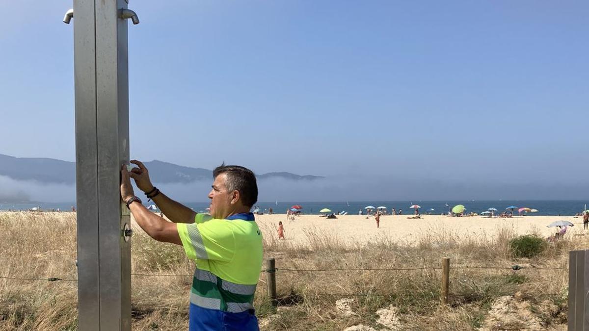 Un operario precintaba ayer una de las duchas de Praia América.