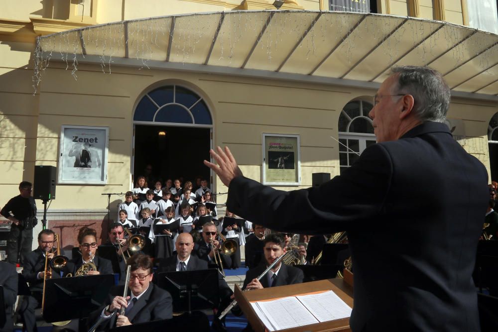 Mil niños de la Fundación Victoria, la Banda Municipal de Málaga y la Escolanía del Corpus Christi ofrecen un concierto navideño frente al teatro malagueño.