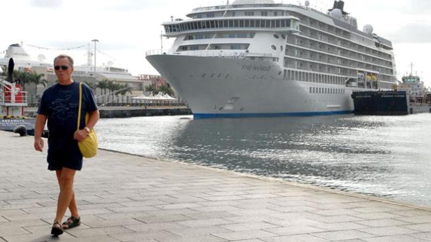 Un turista con el crucero &#039;The World&#039; al fondo, ayer en el Puerto de La Luz. | santi blanco