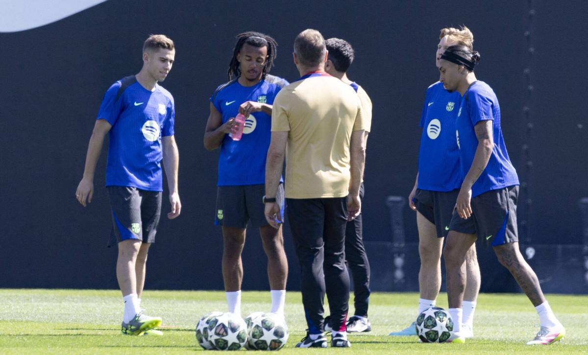Flick habla con varios jugadores en el inicio del entrenamiento.