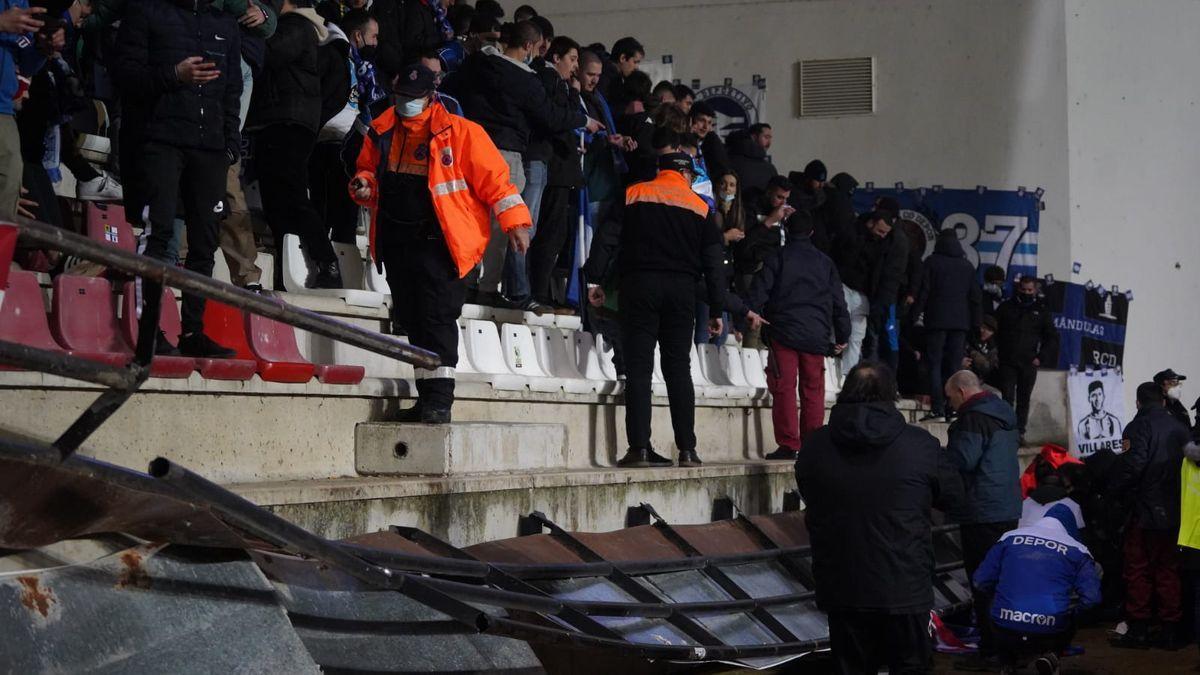 Aficionados en el suelo después de la caída de la valla en el estadio Ruta de la Plata.