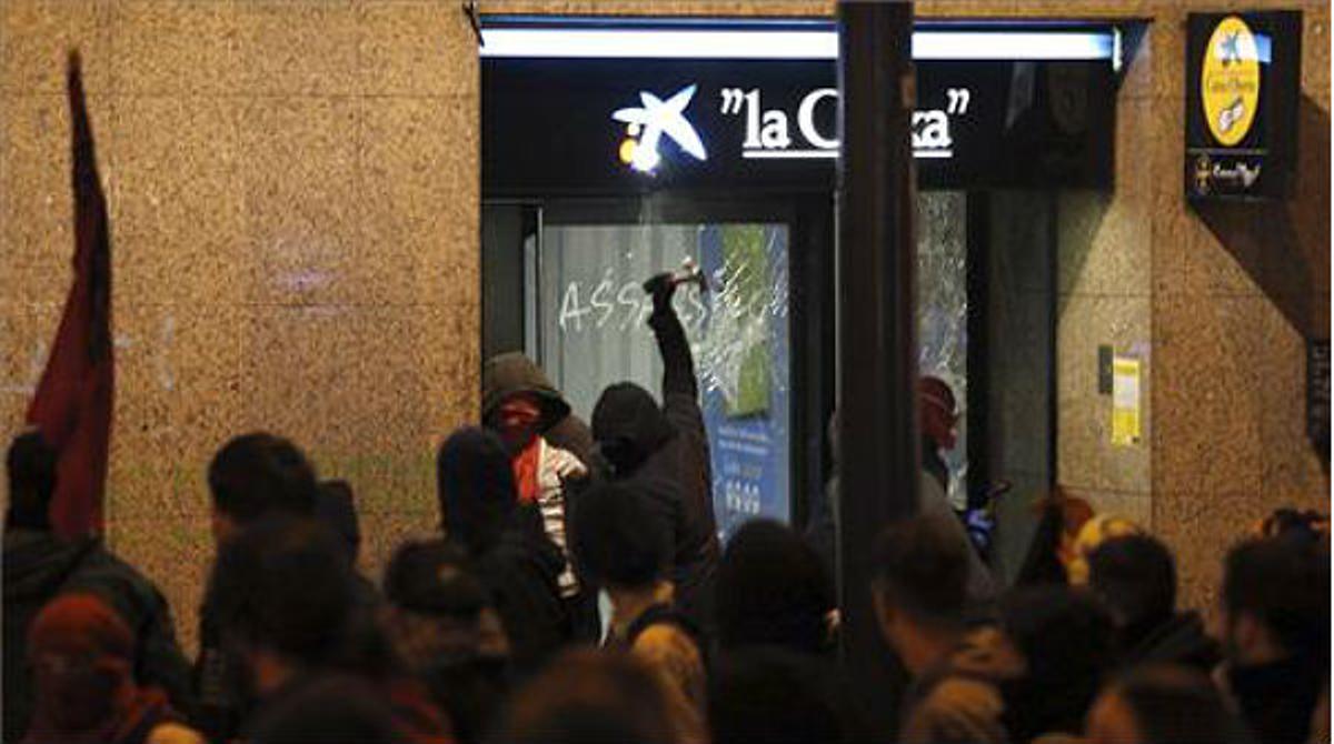 Un grup de manifestants ataquen entitats financeres.
