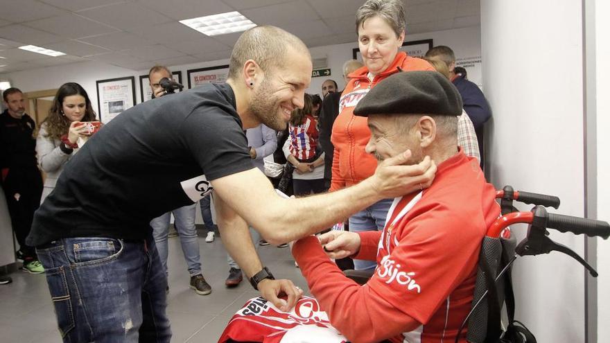 Lora, junto a un aficionado, en su despedida del Sporting.