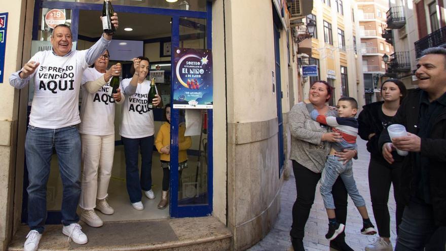 La alegría del premiado: una
botella en una mano y el
boleto en la otra.  Perales Iborra