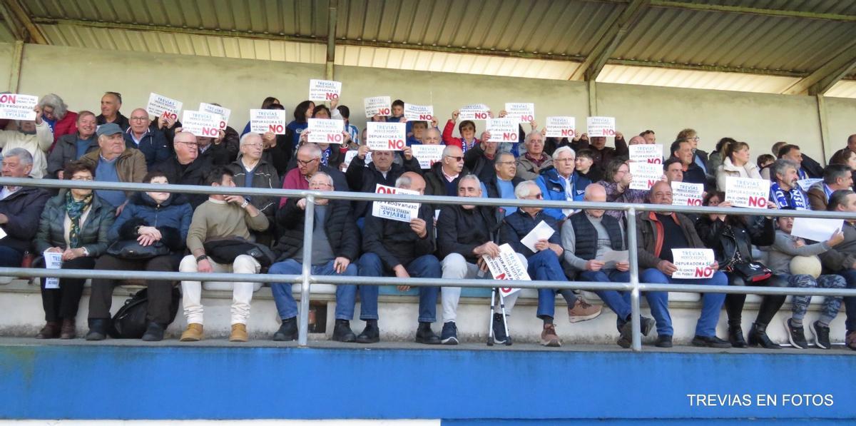 Público en las gradas con con los carteles de protesta.