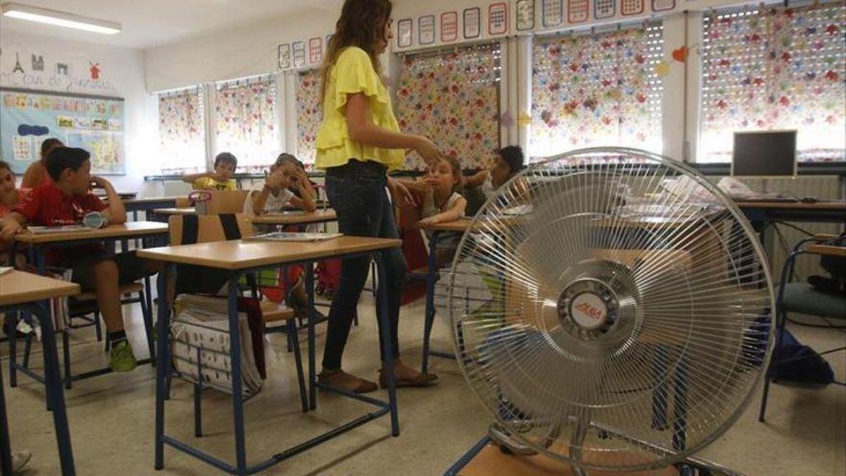 Alumnos de un colegio intentan paliar el calor con un ventilador.