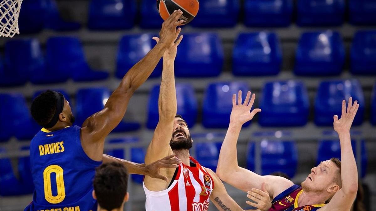 Davies y Smits frenan en ataque a Jagodic, en una acción del partido