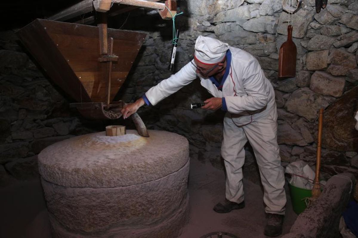 Un integrante de la asociación explica a los jóvenes el funcionamiento de las distintas partes de un molino de agua. |   // SANTOS ÁLVAREZ