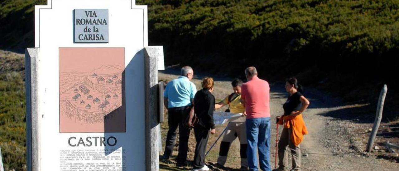 Turistas consultando un mapa en la Carisa, con el polémico indicador en primer término.