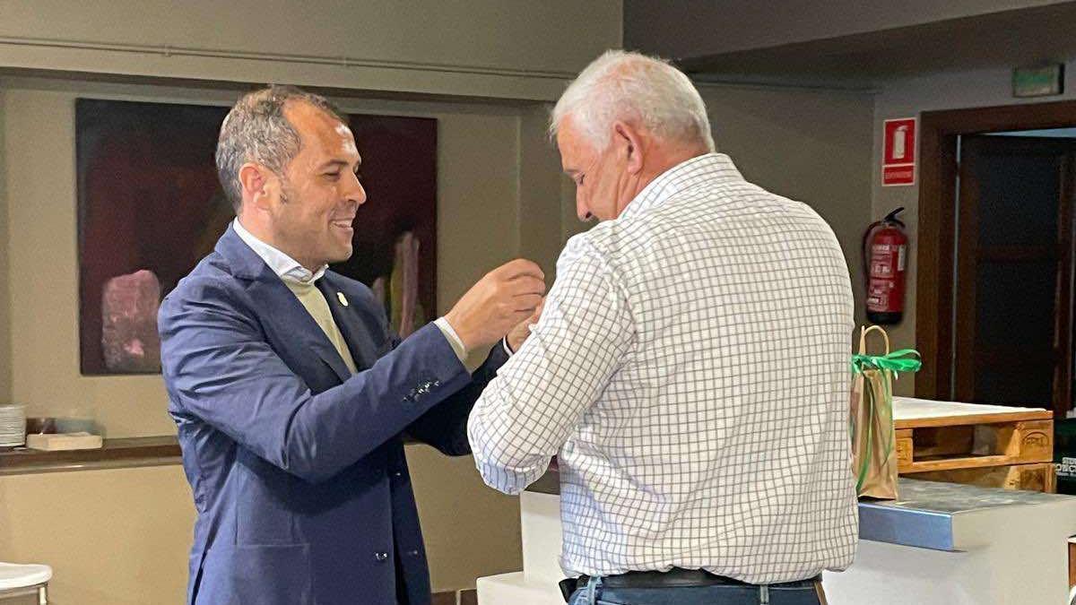 El alcalde cangués impone la insignia de oro a Luis Cortina.
