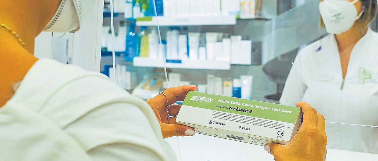 Una usuaria compra un test de antígenos en una farmacia