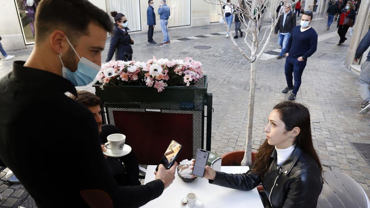 Un camarero comprueba el pasaporte Covid de una clienta.