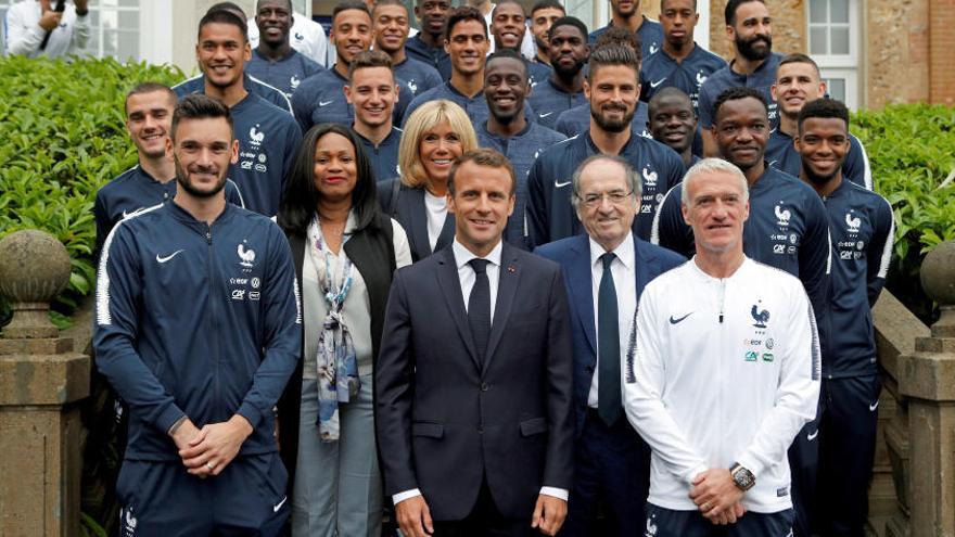 El presidente galo, Emmanuel Macron (c), y su esposa Brigitte (c, detrás) posan con la selección de fútbol francesa.