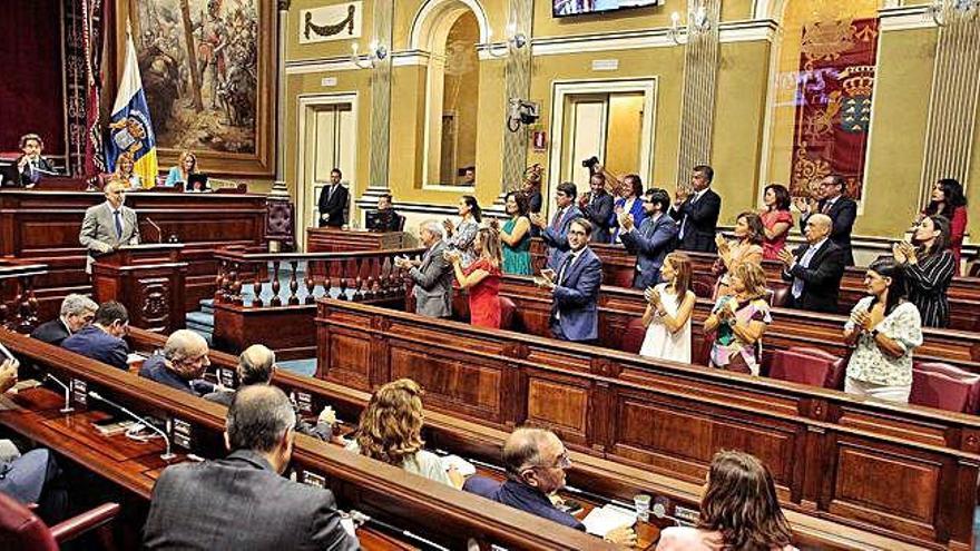 Aplausos en la bancada socialista a Torres mientras la nacionalista permanece sentada.