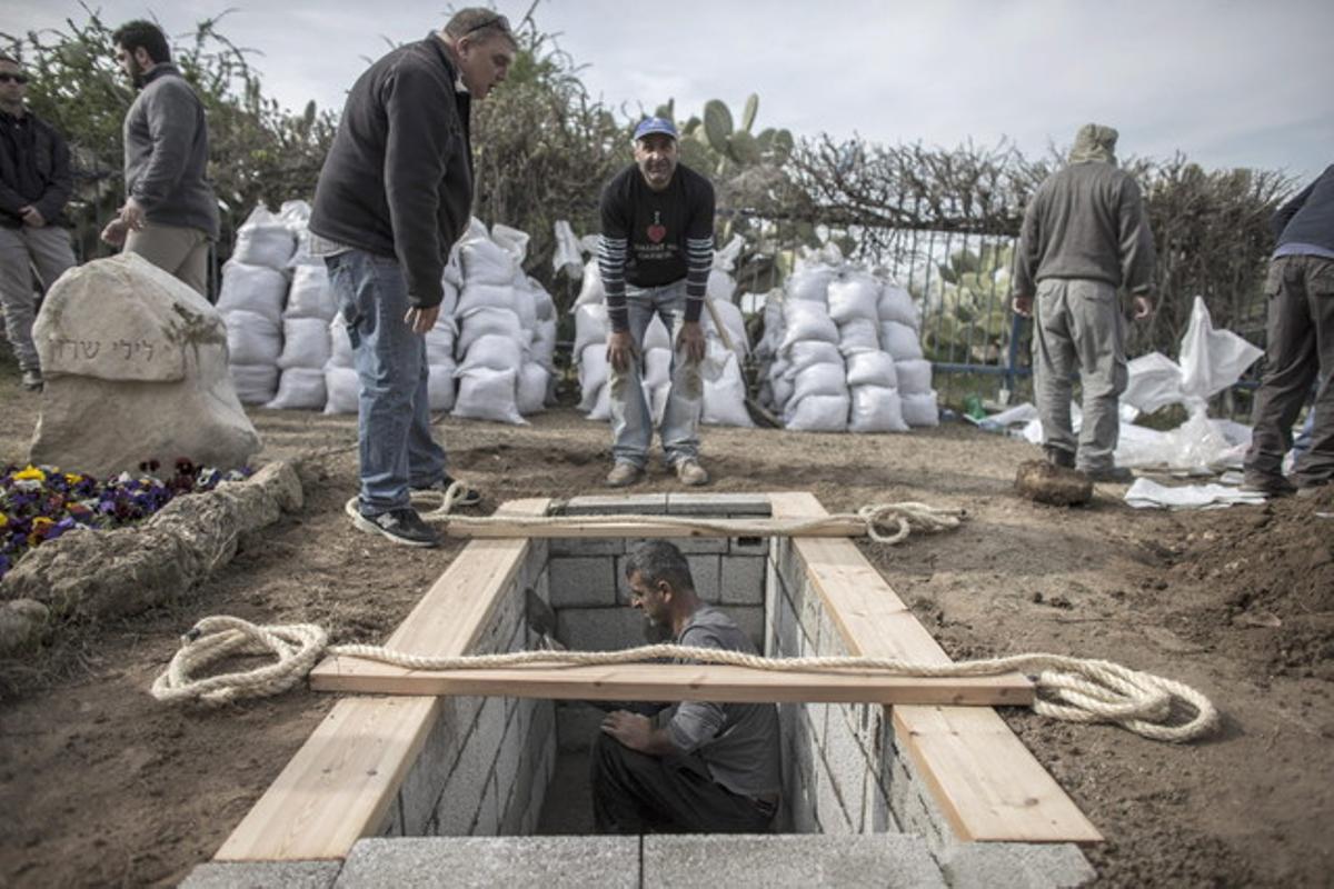 Uns operaris preparen el sepulcre on seran dipositades les restes de Sharon, a la seva granja ranxo Els Sicòmors.