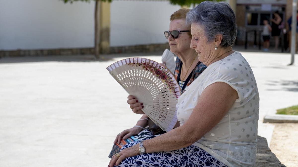 Dos mujeres se refrescan con un abanico durante la ola de calor de este verano en España. 