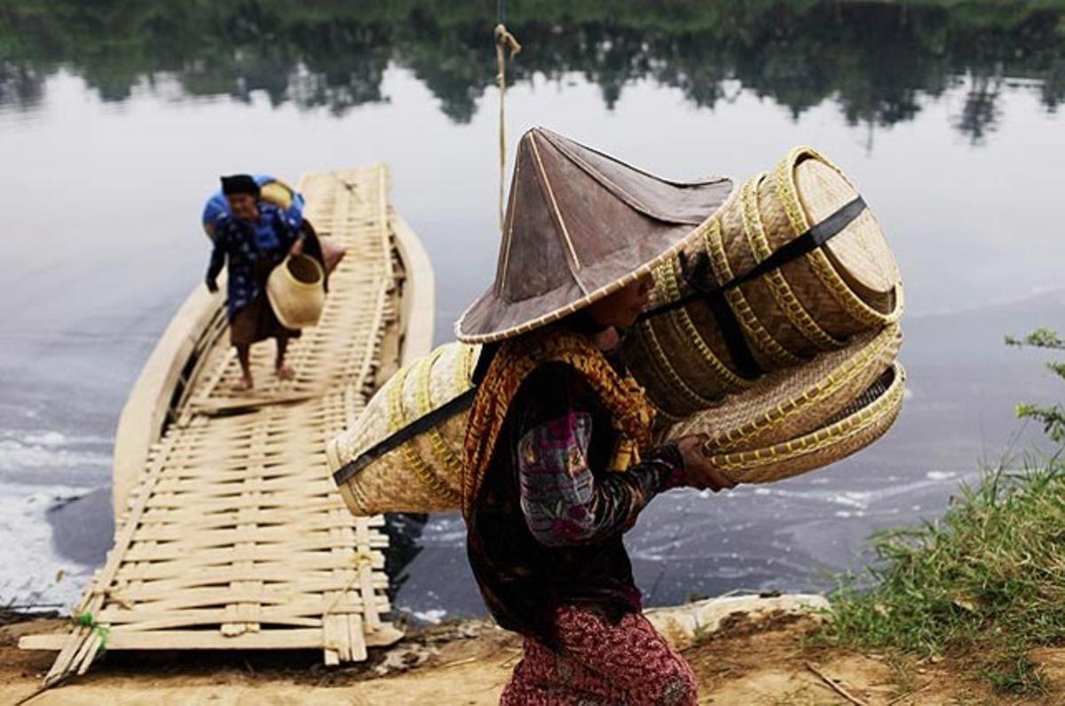 Habitants de la vila d’Astana Agung, a Serang, província indonèsia de Banten, travessen el riu Ciujung, altament contaminat amb residus industrials, per anar a un altre poble a rentar la roba.