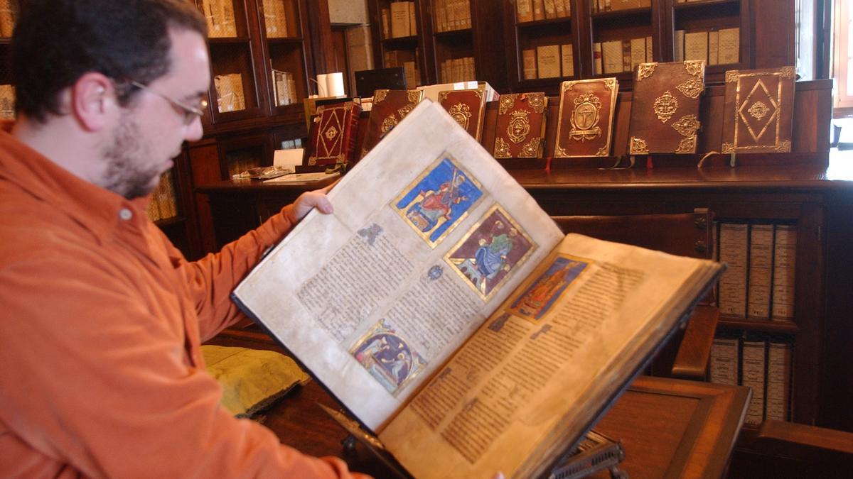 El técnico medievalista de la Catedral de Santiago con el &quot;Tumbo A&quot; entre manos.