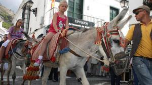 Dos niñas recorren Mijas subidas en un burro taxi, en una imagen de archivo. 