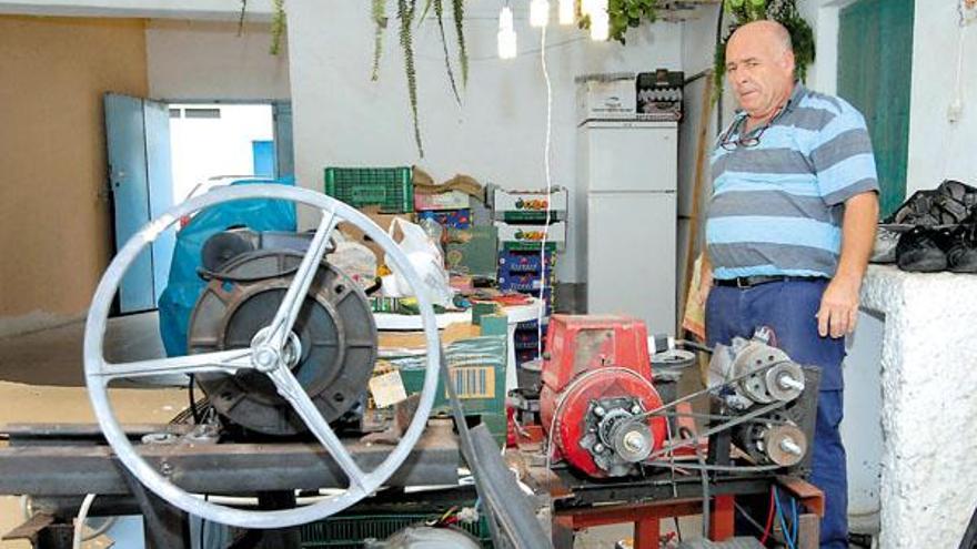 José Luzardo junto al motor de suministro de luz que no necesita combustible para funcionar.