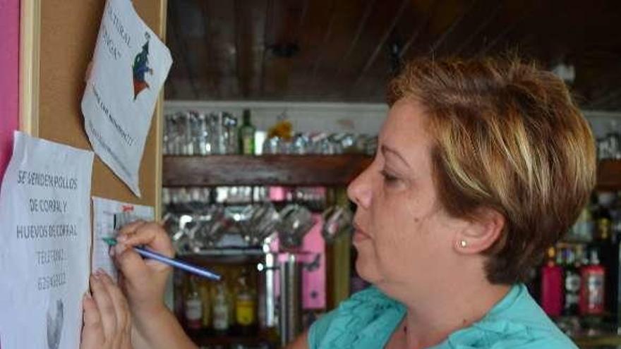 Una mujer estampa su firma en un establecimiento de Mombuey.