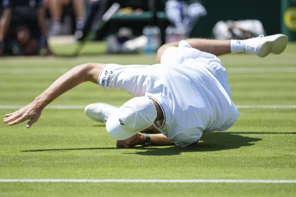 Hubert Hurkacz cae tras resbalarse en su partido ante Fils en Wimbledon.