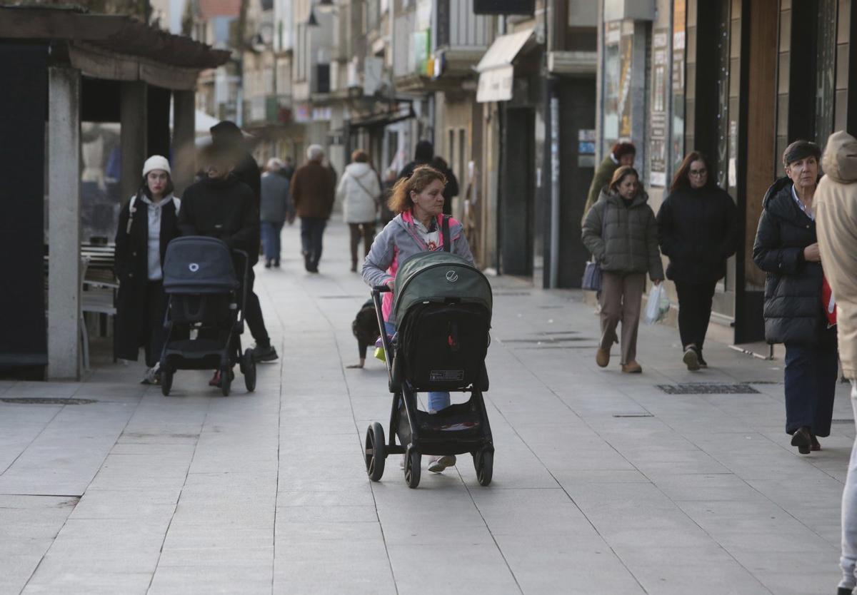 Varias personas con carritos de bebé pasean, en diciembre, por las calles de Cangas. |  S. Álvarez
