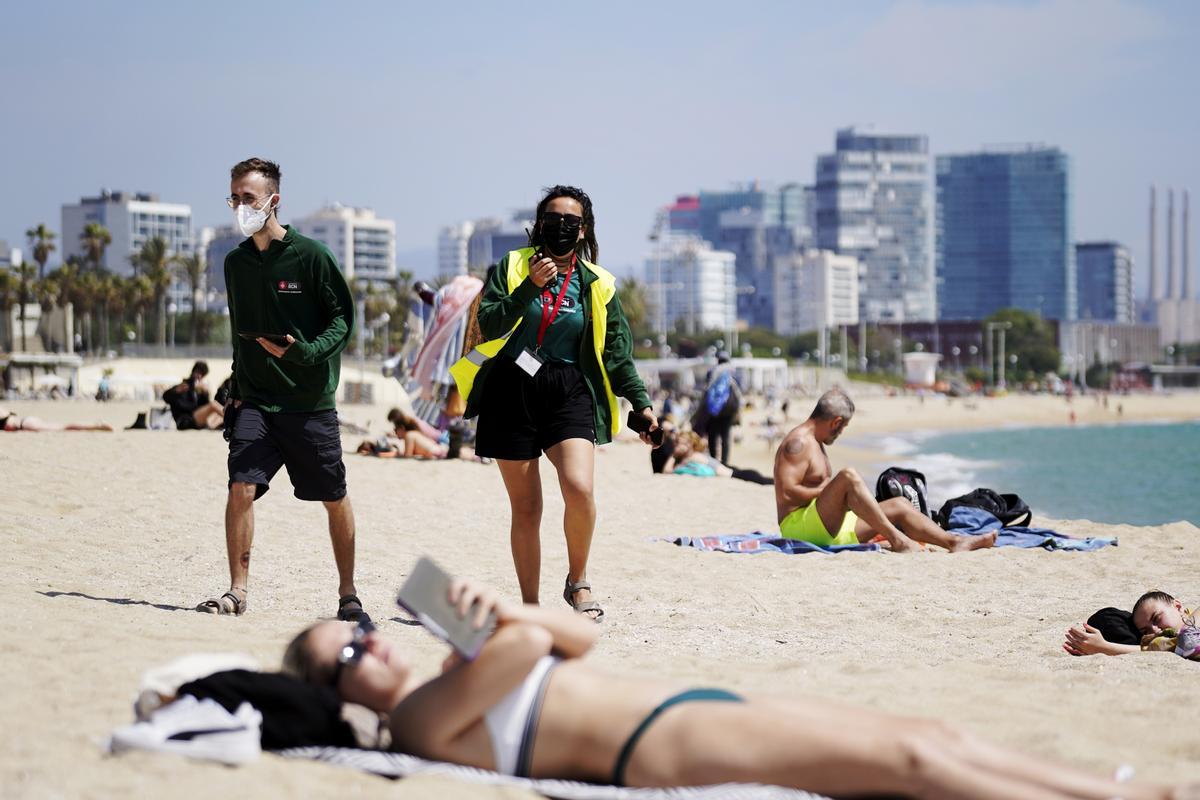 Dos informadores en el control de aforo en la Playa de Bogatell este jueves. 