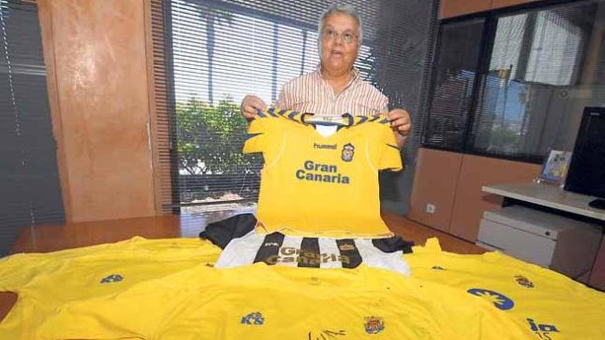 Antonio Cruz Domínguez sostiene una camiseta de la UD sobre otra del Victoria y varias de otras temporadas.