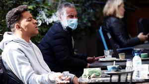 Un hombre fuma en una terraza de Barcelona.