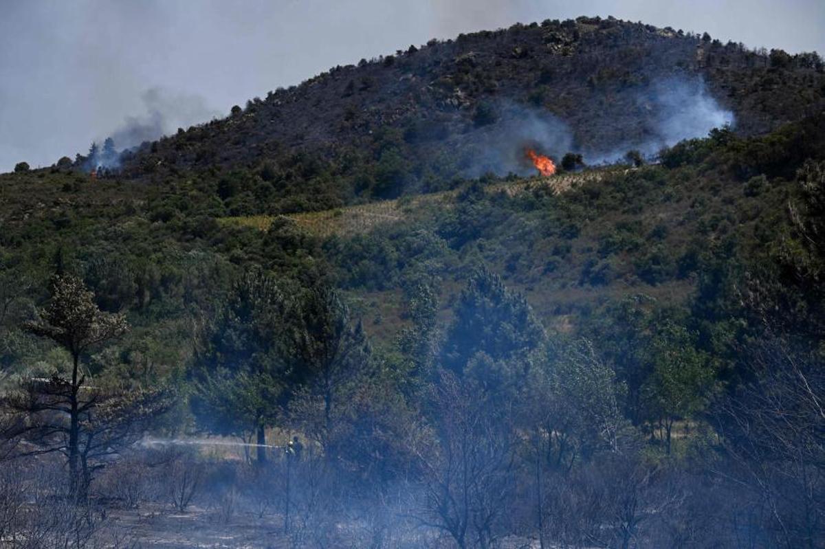 Bomberos franceses lanzan agua para extinguir un incendio forestal cerca de Trevillach, en el sur de Francia, el 5 de julio de 2026.