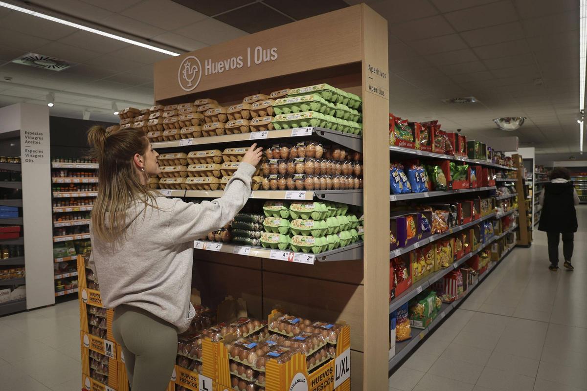 Una clienta coge huevos frescos en un super del port de Sagunt, ayer