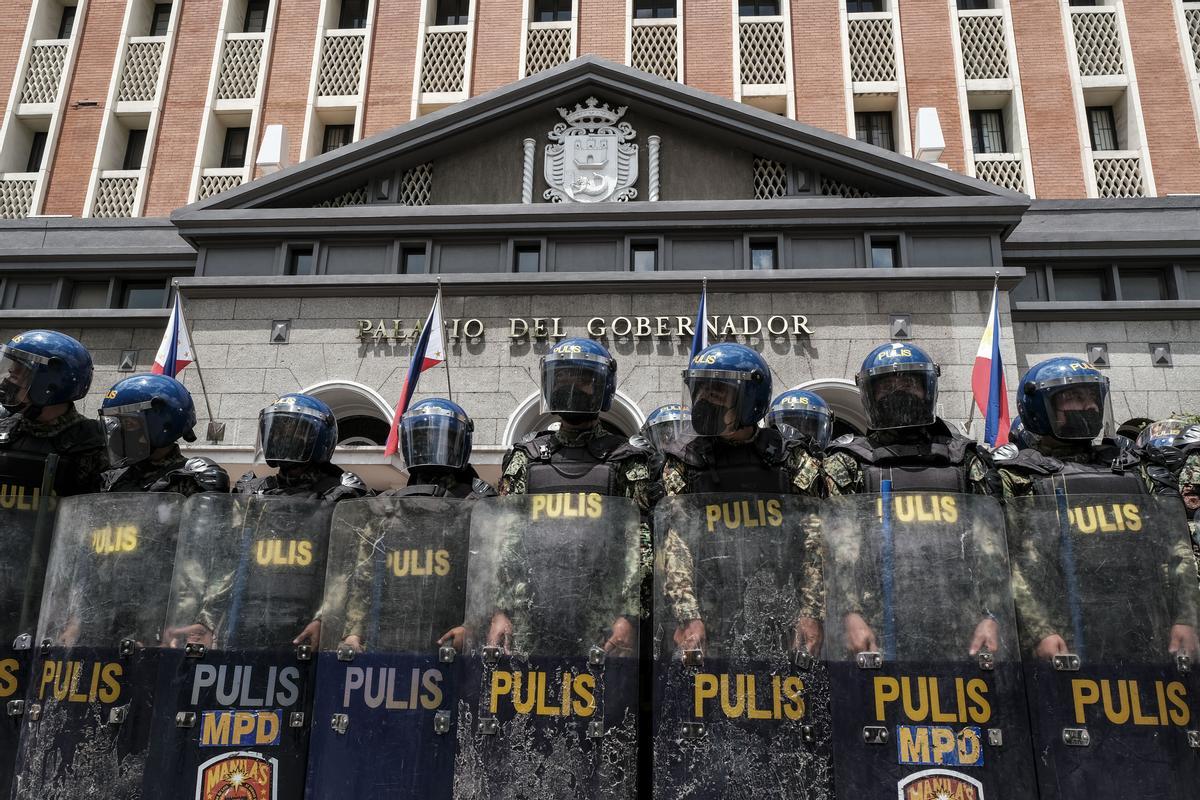 Miembros de los antidisturbios de la Policía Nacional de Filipinas protegen lo oficina de la Comisión de las Elecciones en Manila