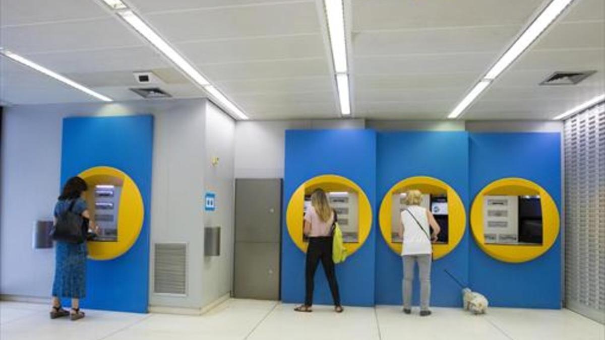 CAIXABANK Clientes en cajeros de la sede de la Diagonal de Barcelona, ayer.