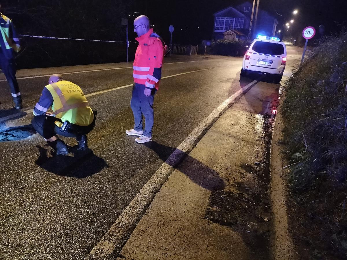 Un agente de la Guardia Civil de Tráfico observa el socavón