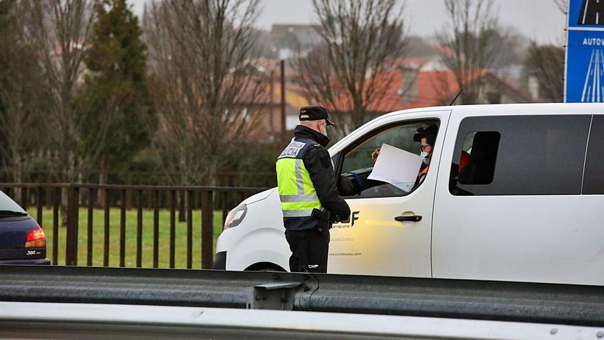 Un trabajador transfronterizo muestra su autorización en un control en la frontera. | // ANXO GUTIÉRREZ