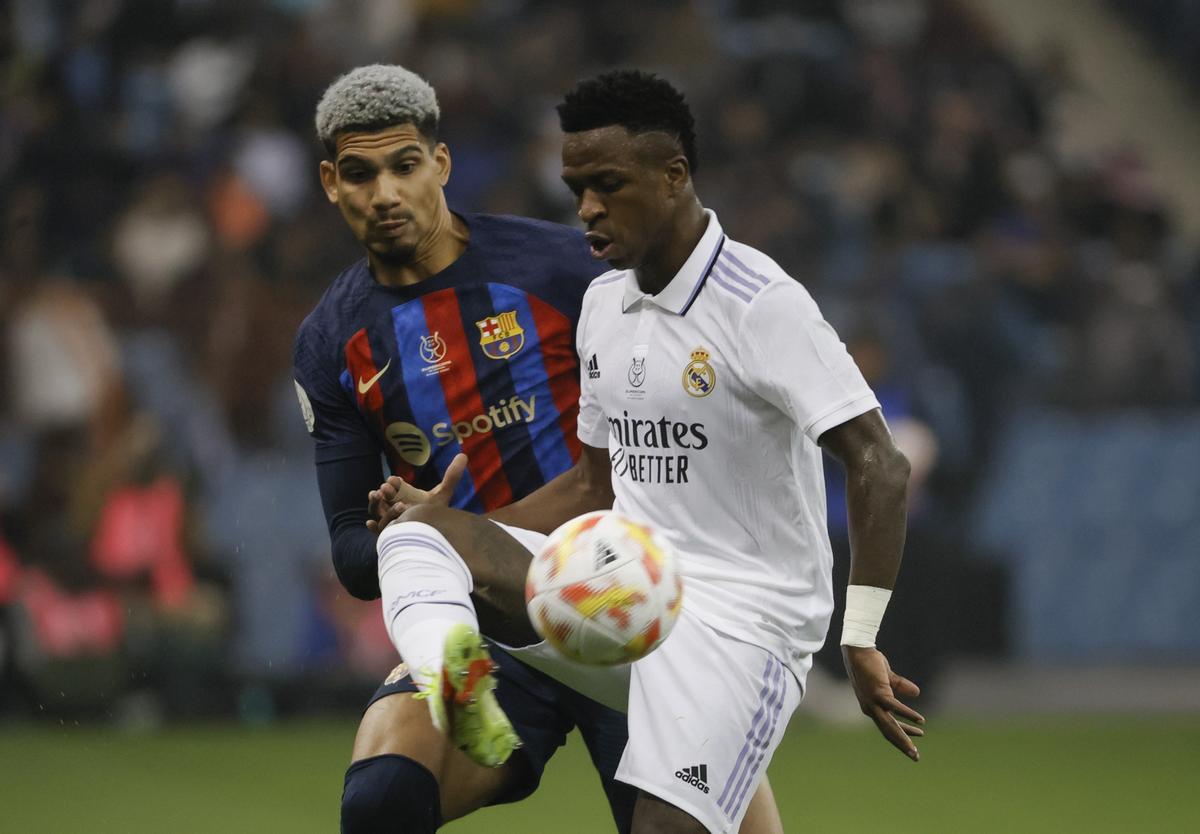 El delantero del Real Madrid, Vinícius Junior,  controla el balón ante el defensa del FC Barcelona, Ronald Araújo , durante el partido de la final de la Supercopa de España 2023, que se juega este domingo en el Estadio Internacional Rey Fahd de Riad, Arabia Saudí.