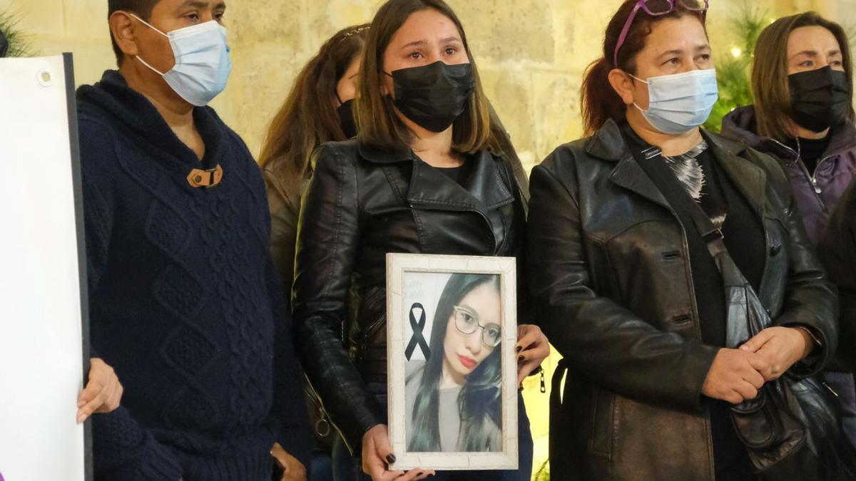 La hermana de la víctima sostiene una fotografía junto a su madre y otros miembros de la familia. | ÁXEL ÁLVAREZ