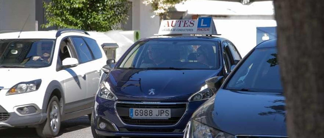 Un coche de autoescuela circula por las calles del casco urbano de Lalín. // Bernabé