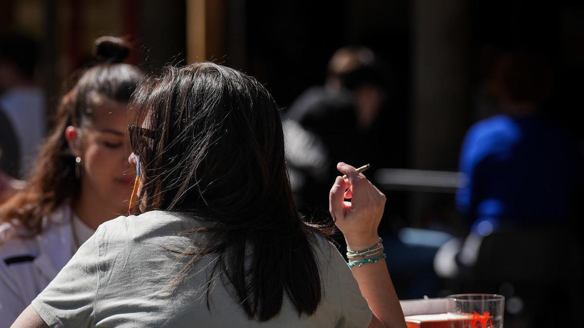 Una persona fumando en una terraza.