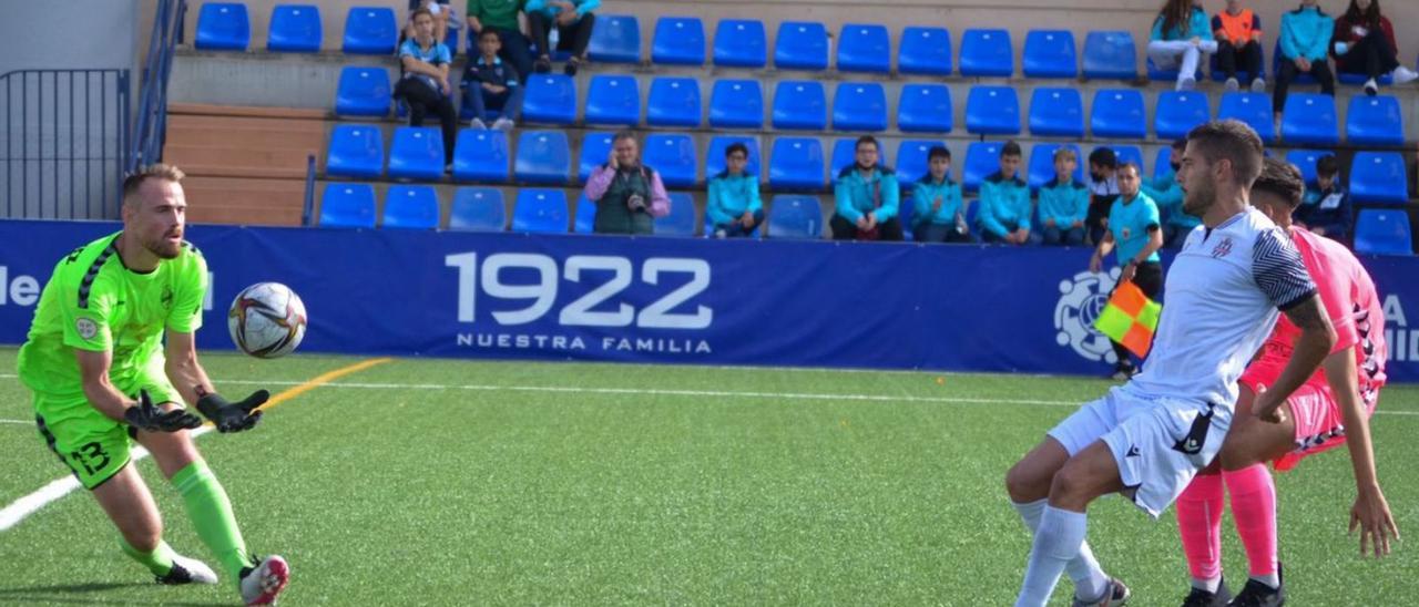 Javi Sánchez, por tero del Tamaraceite, se hace con el balón ante la presión de un jugador del Vélez. | | VÉLEZ CF