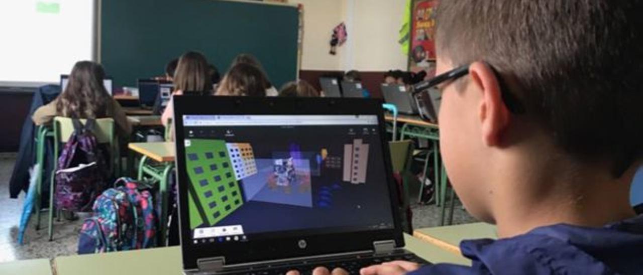 Un alumno trabajando con un ordenador portatil en clase