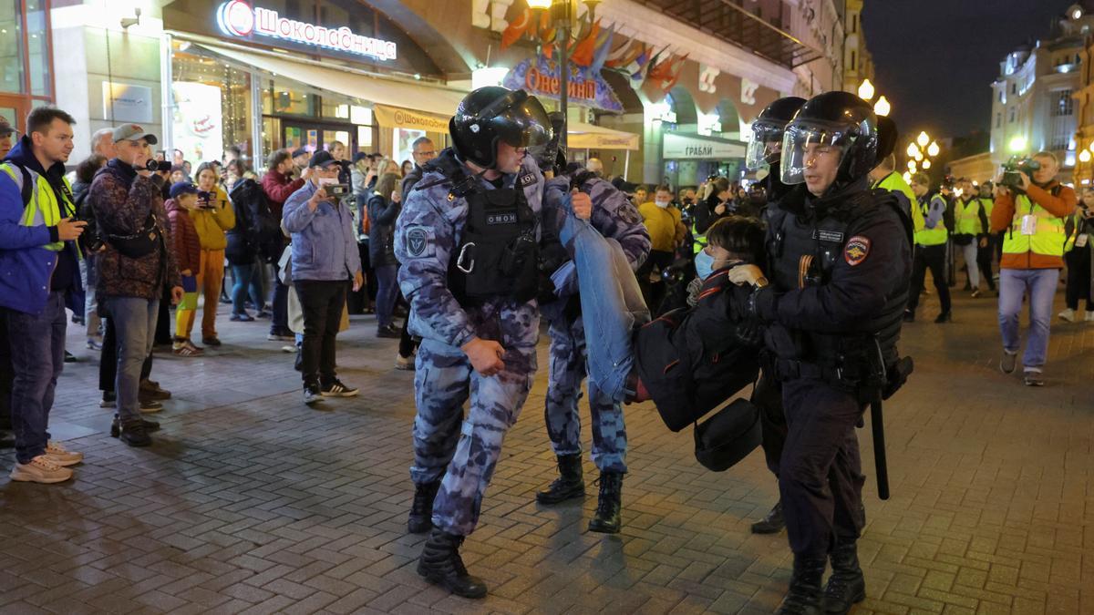 Russian police officers detain a person during an unsanctioned rally in Moscow