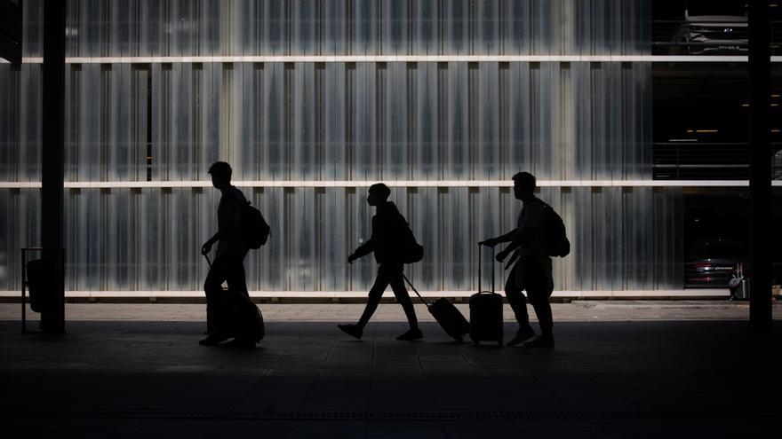 Archivo - Tres personas caminan junto a su equipaje en el Aeropuerto de Barcelona-El Prat, Barcelona, Catalunya (España).