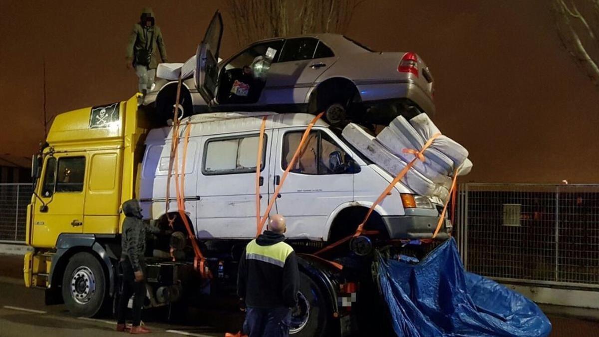 Un camión circula cargado con una fuergoneta, un coche y 4 colchones