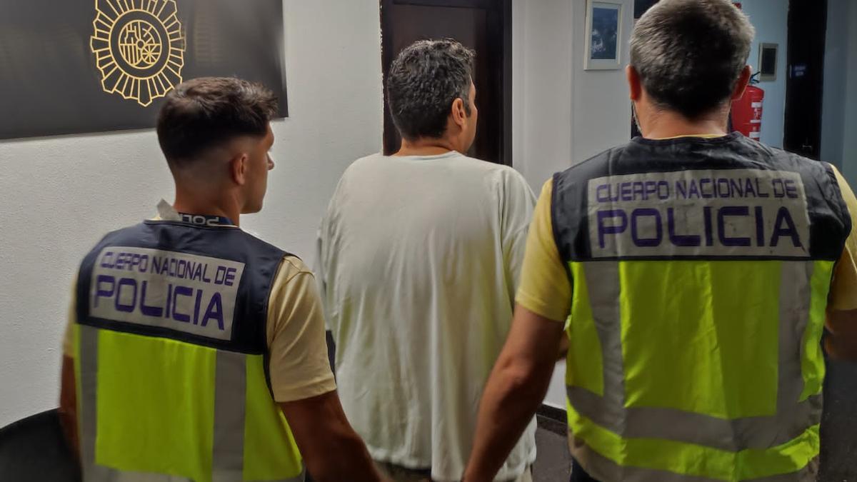 El detenido, custodiado por dos agentes de Policía.